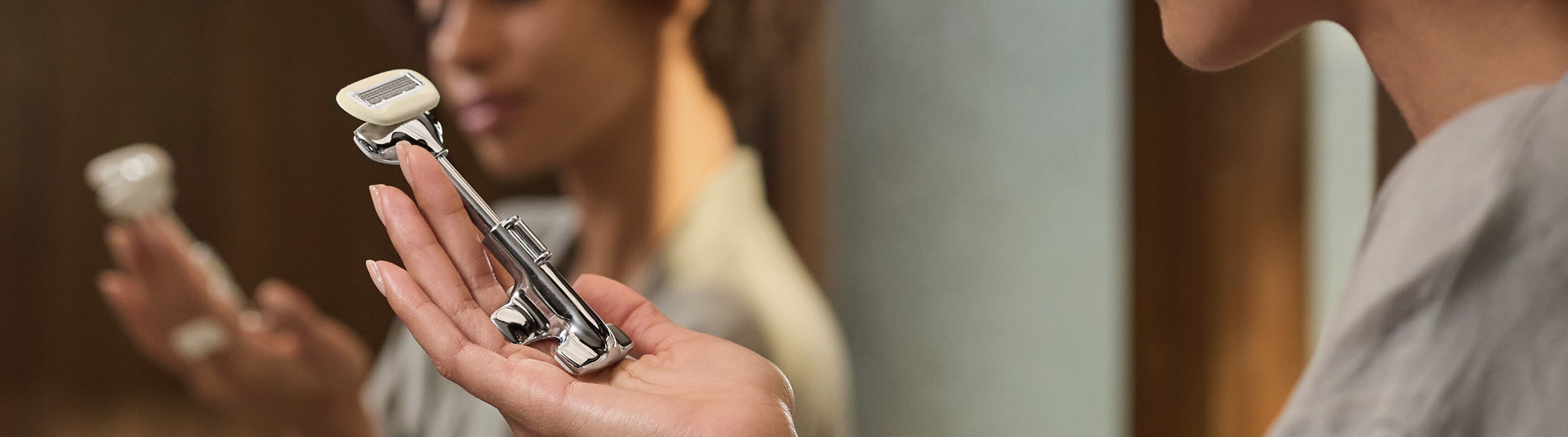 Person holding a safety razor with blurred background