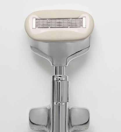 Shaving razor with beige handle on a white background