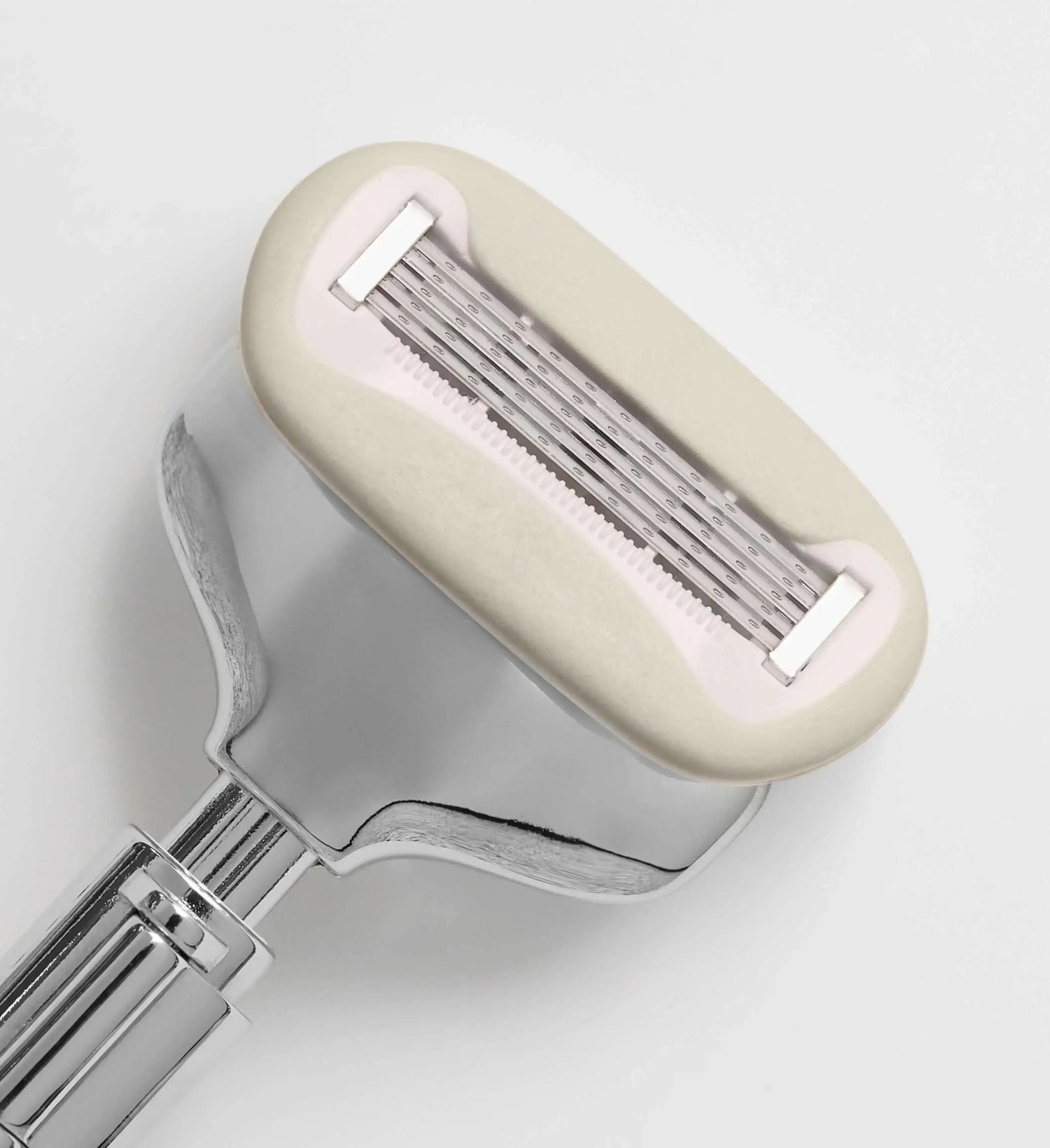 Shaving razor with cream handle on a light gray background
