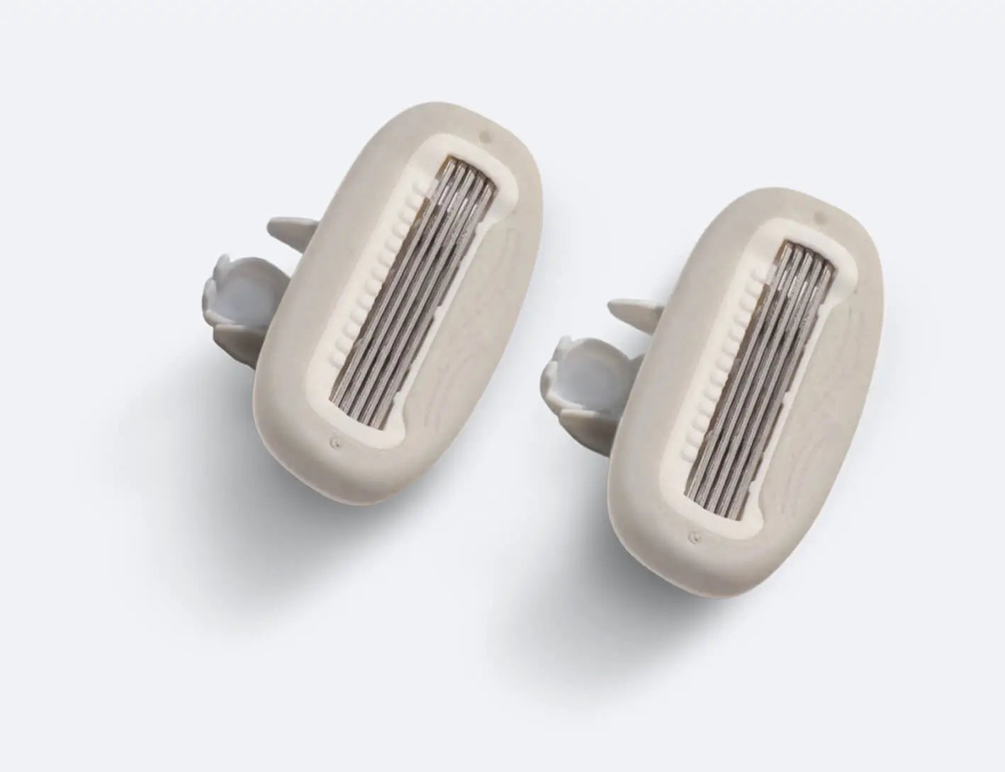 Pair of beige earbud covers on a white background
