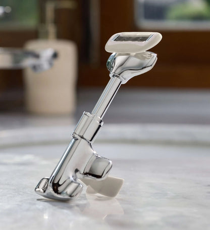 Metal shaving razor on a marble countertop with blurred background