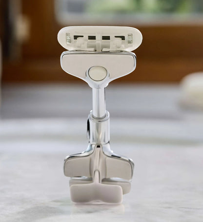 Silver razor on a white surface with a blurred background