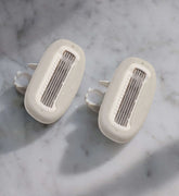 Two razor blade cartridges on a marble countertop