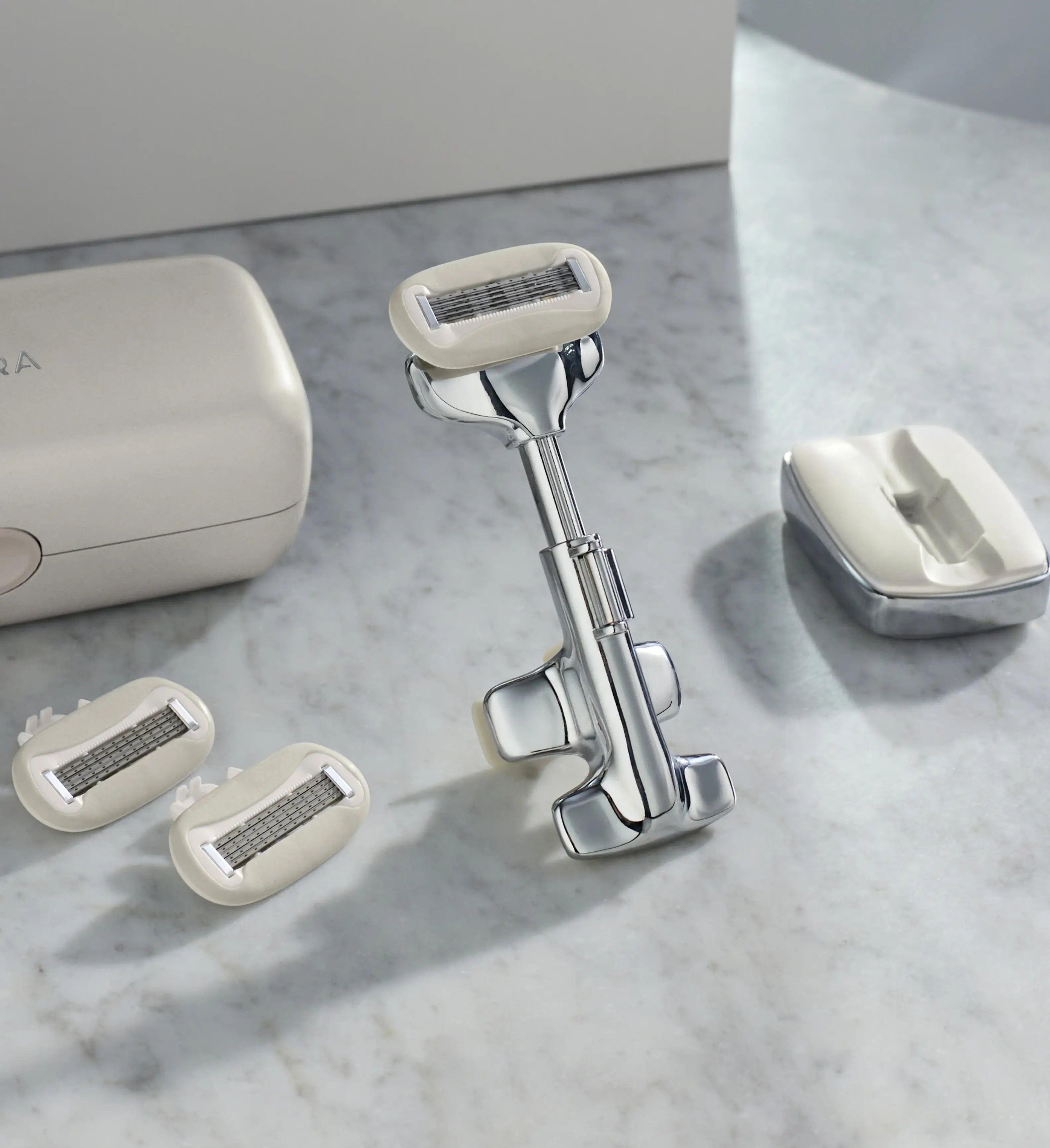 Shaving system with razor and replacement heads on a marble surface