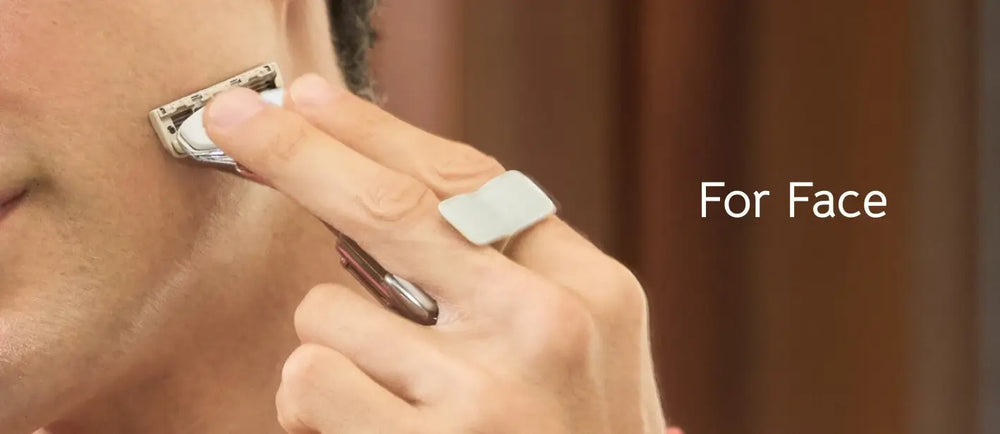 Person using a face razor on their cheek with a blurred background