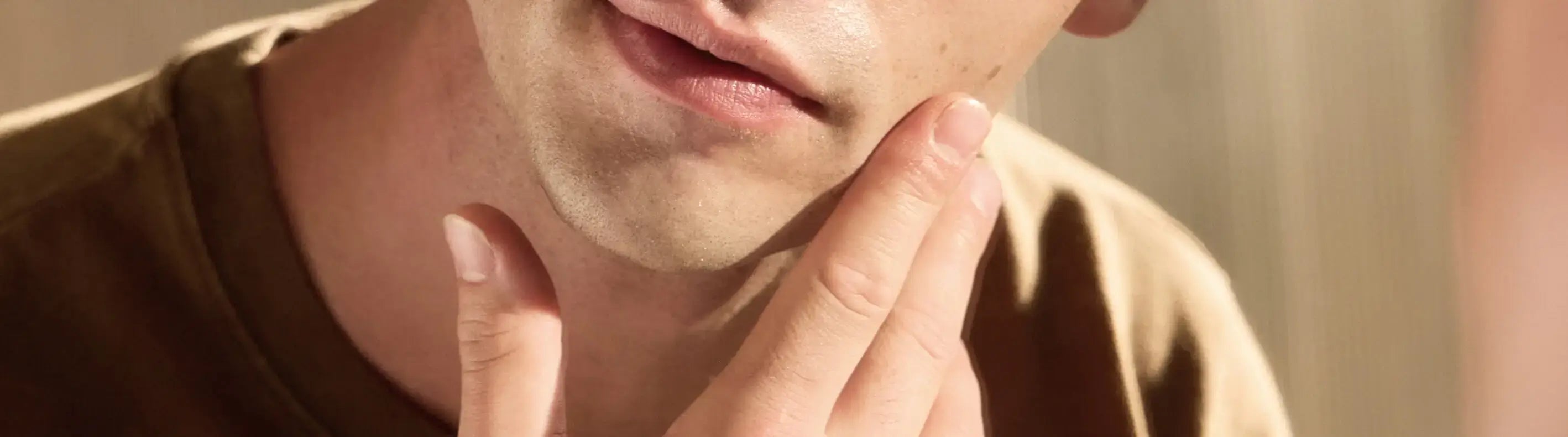 Close-up of a person touching their chin with a blurred background